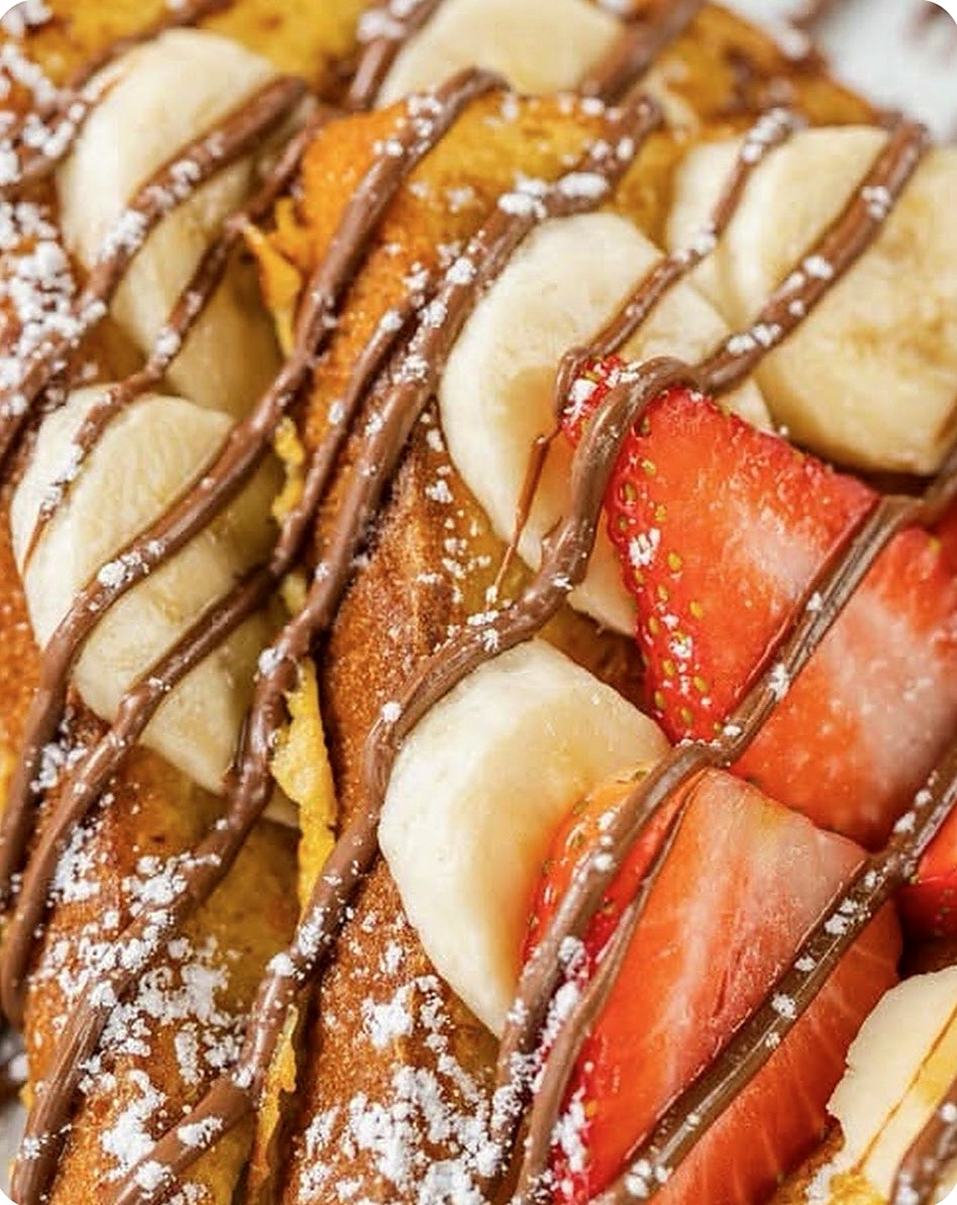 Nutella drizzled French toast with banana and strawberry slices